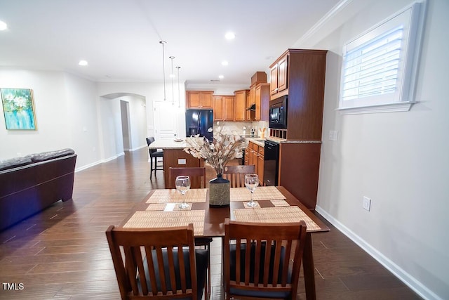 dining area with dark wood-type flooring and ornamental molding