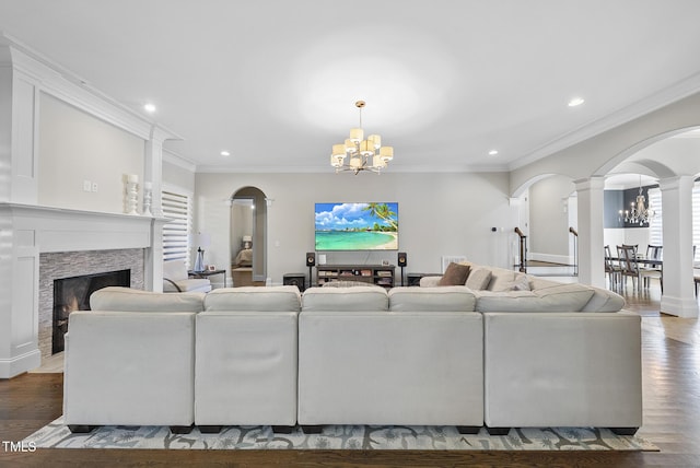 living room featuring ornate columns, crown molding, a chandelier, and hardwood / wood-style floors