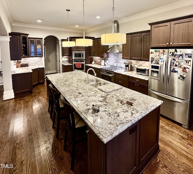 kitchen featuring sink, pendant lighting, stainless steel appliances, and an island with sink