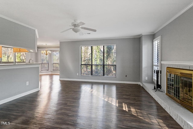 unfurnished living room with ornamental molding, dark wood-type flooring, and ceiling fan with notable chandelier