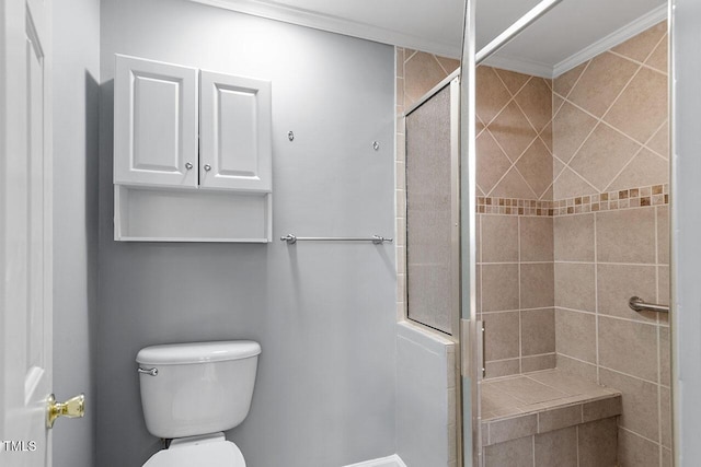 bathroom featuring toilet, a shower with shower door, and ornamental molding