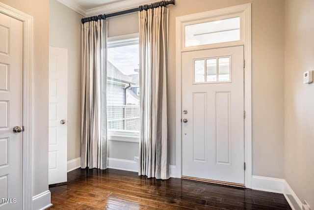 entryway with dark wood-type flooring and ornamental molding