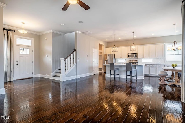 interior space featuring dark wood-type flooring, ceiling fan, and crown molding