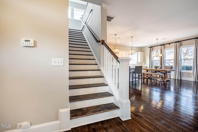 stairs with an inviting chandelier and hardwood / wood-style floors