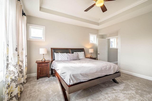 carpeted bedroom featuring multiple windows, crown molding, and a raised ceiling