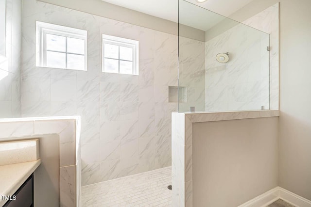 bathroom featuring vanity and tiled shower