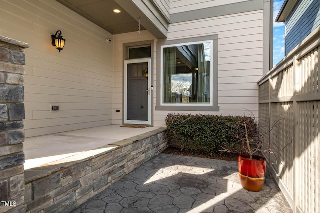 view of exterior entry with a patio area