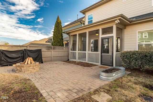 view of patio with a sunroom and an outdoor fire pit