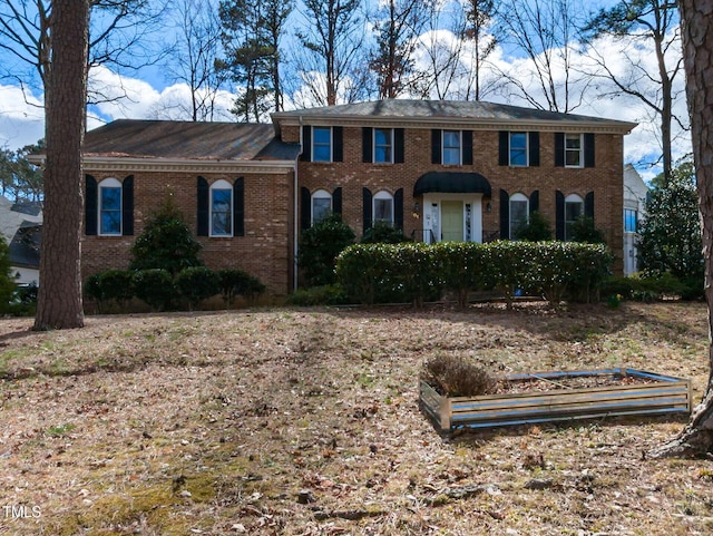 colonial inspired home with brick siding