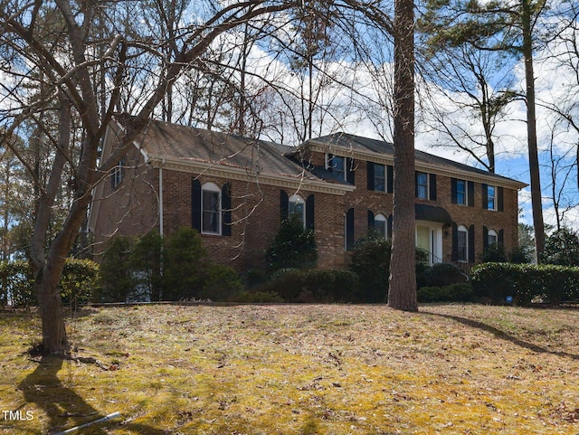 colonial inspired home with brick siding