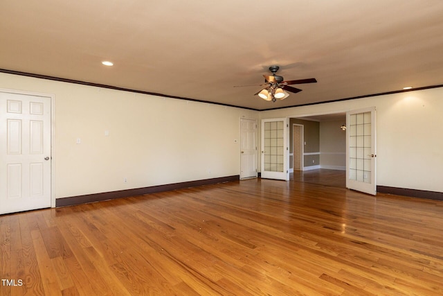 empty room featuring baseboards, ceiling fan, ornamental molding, french doors, and light wood-type flooring