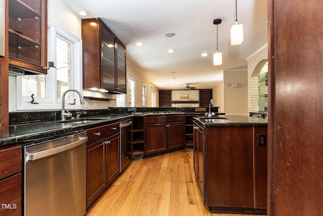 kitchen featuring light wood-type flooring, a sink, decorative light fixtures, glass insert cabinets, and dishwasher