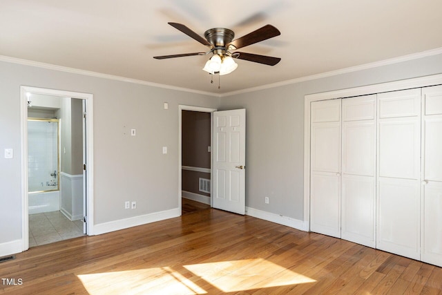 unfurnished bedroom featuring visible vents, light wood-style flooring, and ornamental molding