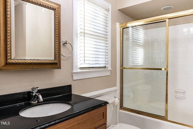 full bath featuring bath / shower combo with glass door, toilet, and vanity