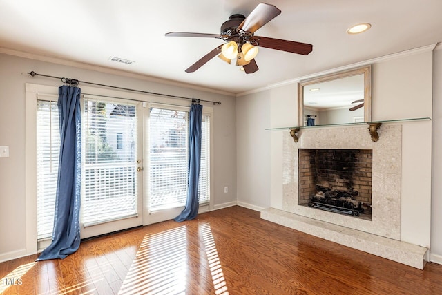 unfurnished living room with crown molding, wood finished floors, and visible vents