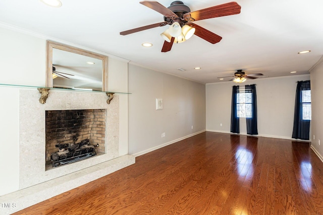 unfurnished living room featuring wood finished floors, crown molding, baseboards, and a premium fireplace