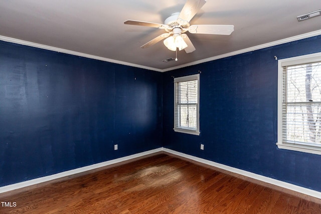 unfurnished room featuring visible vents, a healthy amount of sunlight, and crown molding