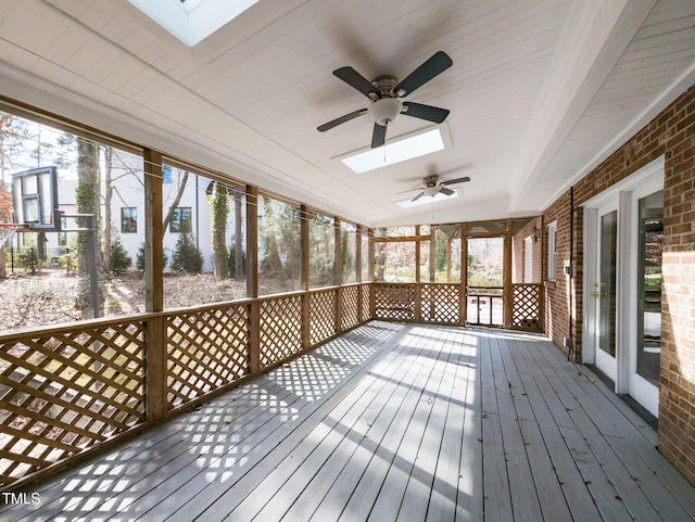 unfurnished sunroom with a skylight, a wealth of natural light, and ceiling fan