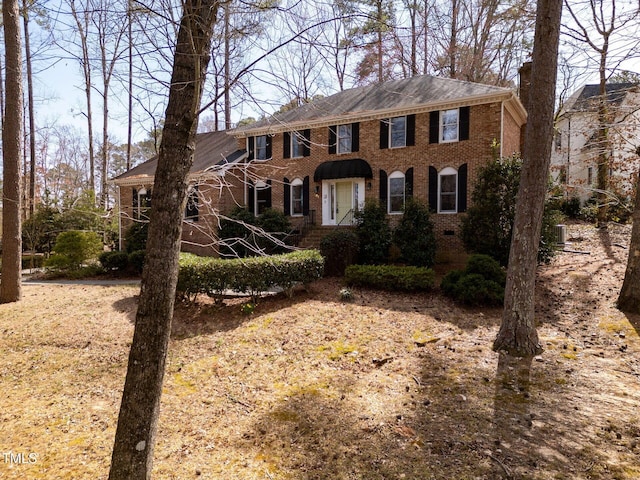 colonial house featuring brick siding