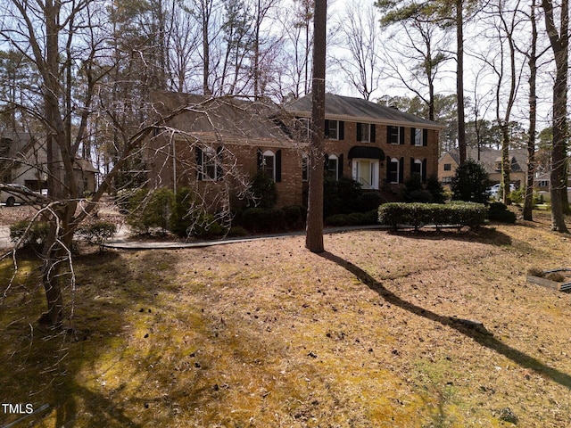 colonial inspired home featuring brick siding