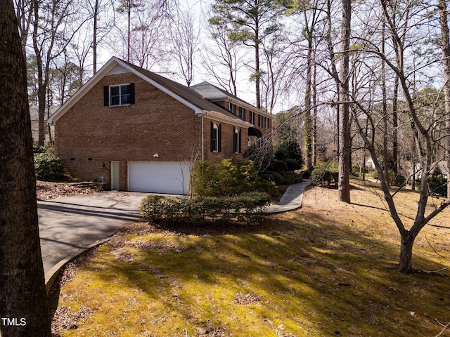 view of home's exterior featuring concrete driveway, a garage, and brick siding