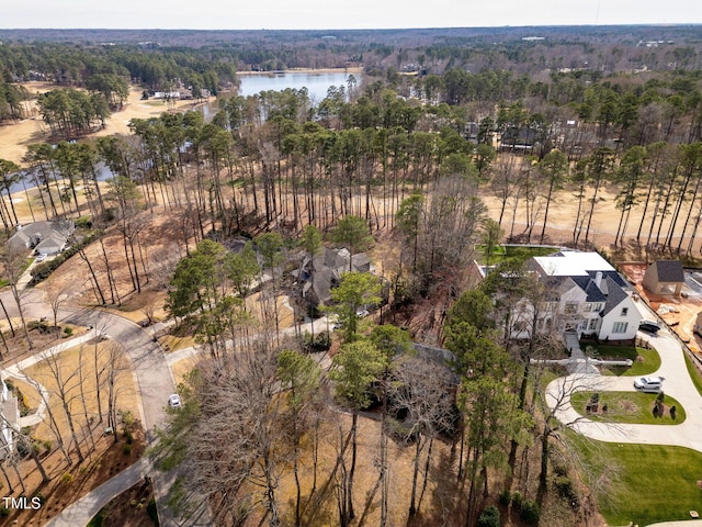 birds eye view of property featuring a forest view and a water view