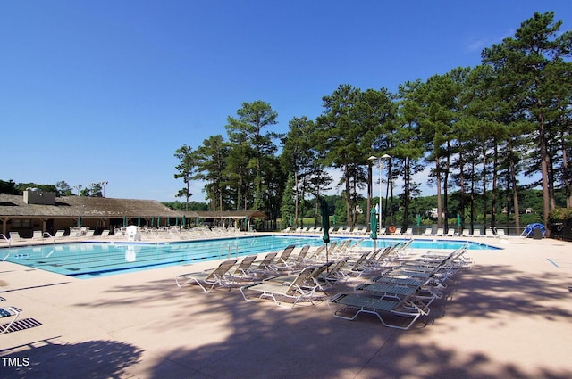 community pool with a patio and fence