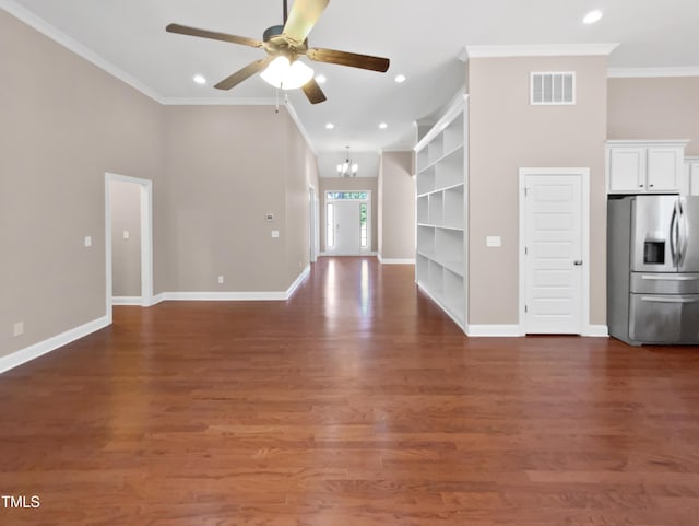 unfurnished living room featuring ceiling fan with notable chandelier, a high ceiling, built in shelves, dark hardwood / wood-style flooring, and ornamental molding