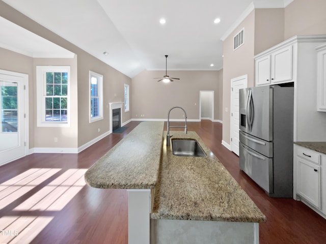 kitchen featuring a kitchen island with sink, white cabinets, stainless steel refrigerator with ice dispenser, and sink