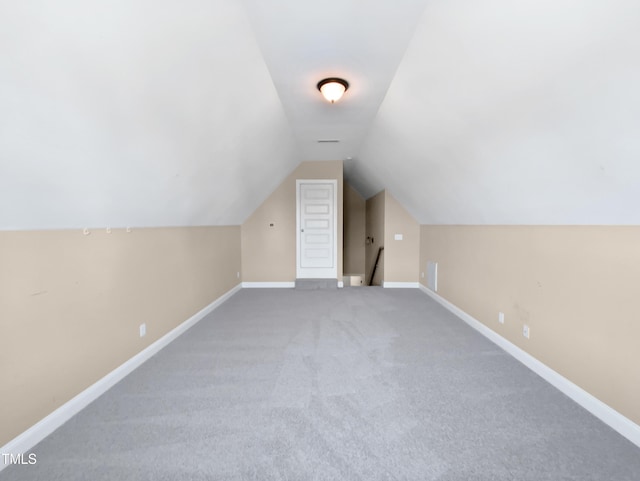 additional living space featuring carpet flooring and vaulted ceiling