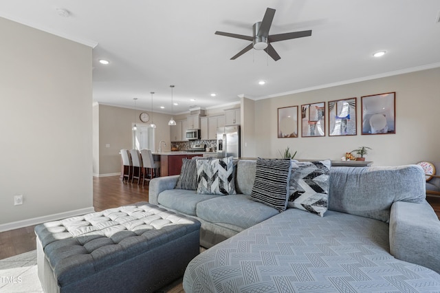 living room featuring ceiling fan, wood-type flooring, and crown molding