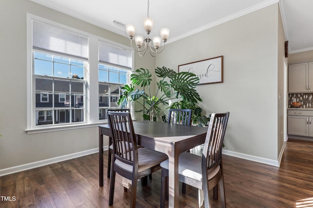 dining room featuring dark hardwood / wood-style flooring, ornamental molding, and a notable chandelier