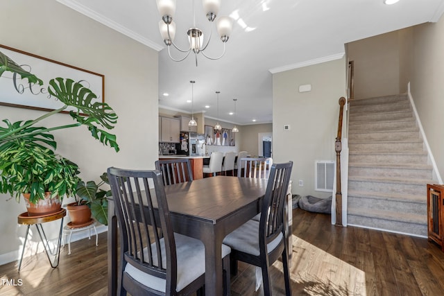 dining space with dark hardwood / wood-style flooring, crown molding, and a chandelier