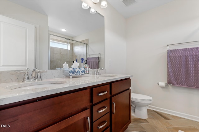 bathroom featuring a shower with shower door, toilet, and vanity