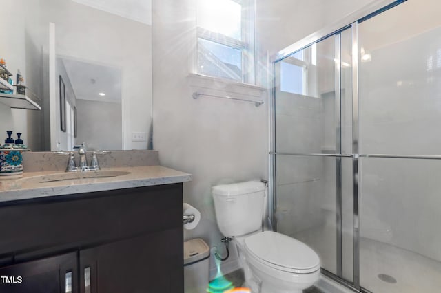 bathroom with a shower with door, toilet, and vanity