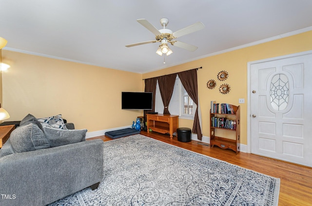 living room featuring ceiling fan, ornamental molding, and hardwood / wood-style flooring