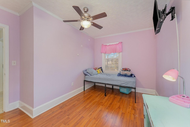 bedroom featuring light hardwood / wood-style floors, ceiling fan, crown molding, and a textured ceiling