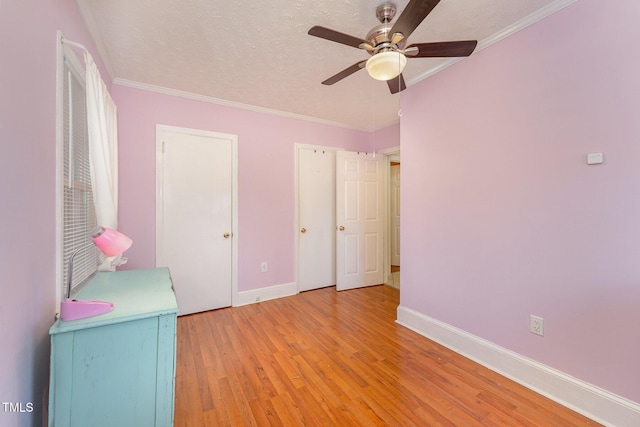 unfurnished bedroom featuring a textured ceiling, ceiling fan, light wood-type flooring, and ornamental molding