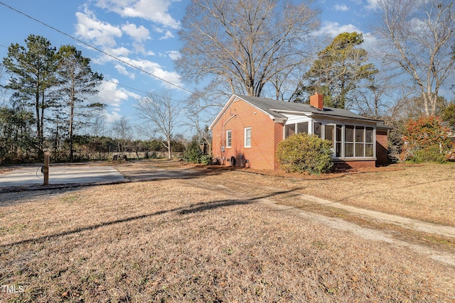 view of side of home with a yard and a sunroom