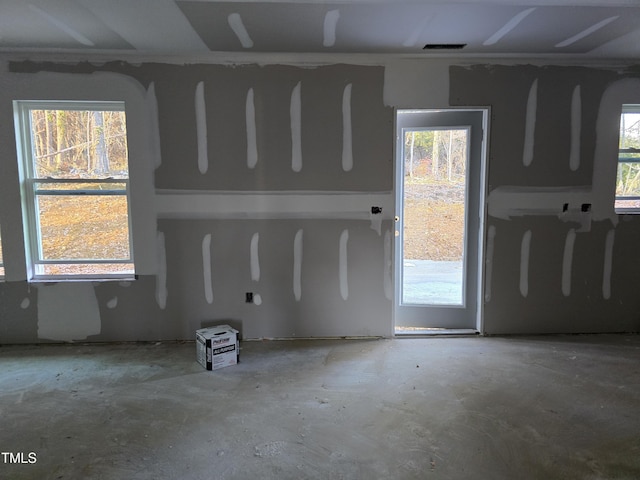 empty room with concrete flooring and a healthy amount of sunlight