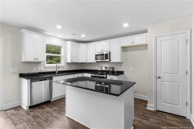 kitchen featuring appliances with stainless steel finishes, a center island, white cabinets, and sink