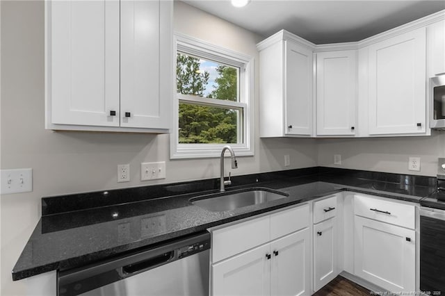 kitchen featuring sink, stainless steel appliances, white cabinetry, and dark stone counters