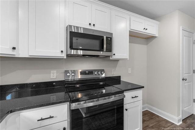 kitchen featuring white cabinetry, dark hardwood / wood-style floors, dark stone counters, and appliances with stainless steel finishes