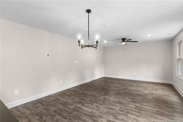 empty room featuring ceiling fan with notable chandelier and dark hardwood / wood-style flooring