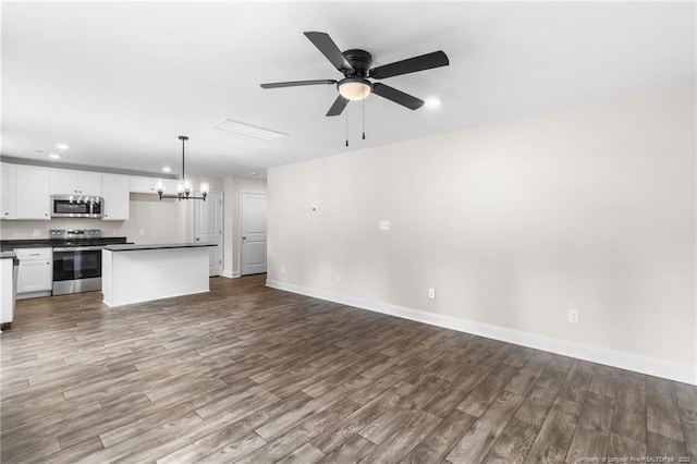 unfurnished living room featuring ceiling fan with notable chandelier and hardwood / wood-style floors