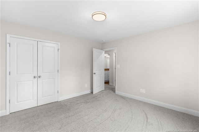 unfurnished bedroom featuring a closet and light colored carpet