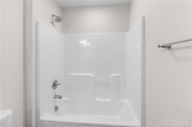 bathroom featuring toilet and shower / bathing tub combination