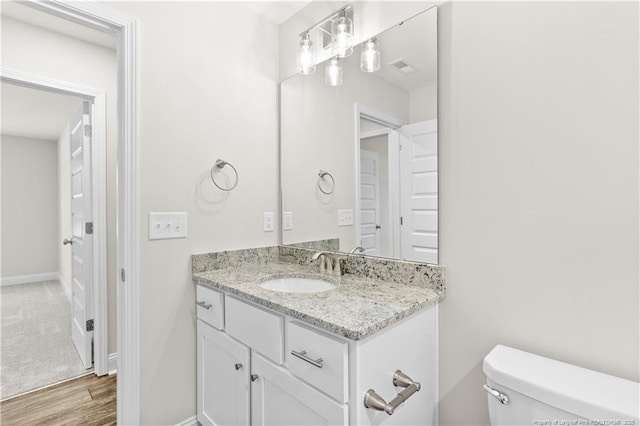 bathroom featuring hardwood / wood-style floors, vanity, and toilet