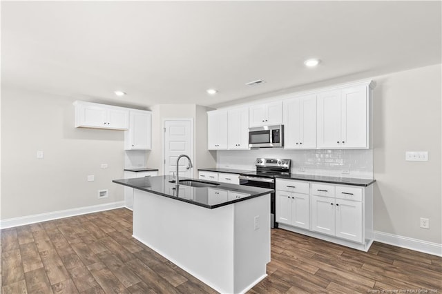 kitchen with stainless steel appliances, a center island with sink, white cabinetry, and sink