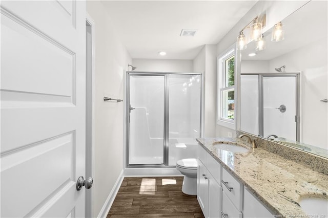 bathroom with toilet, wood-type flooring, and a shower with shower door